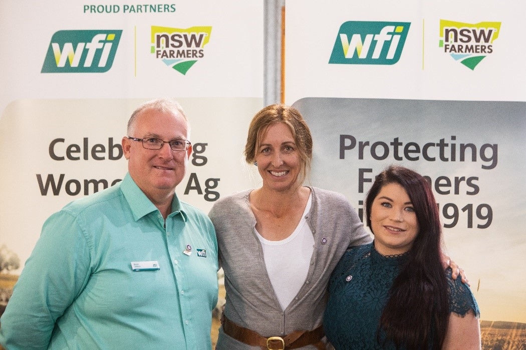 WFI staff standing with next to two ladies