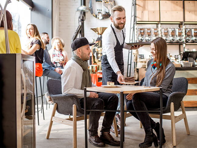 Couple being coffee served in a cafe.